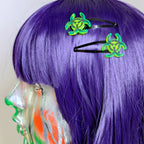 Purple wig with green biohazard symbol hair clips on a white background